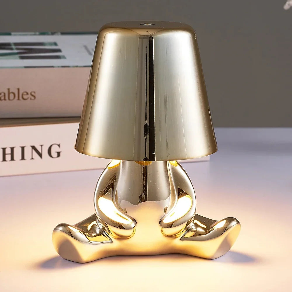 Designerska lampa stołowa LED siedzący człowiek z połyskującym wykończeniem