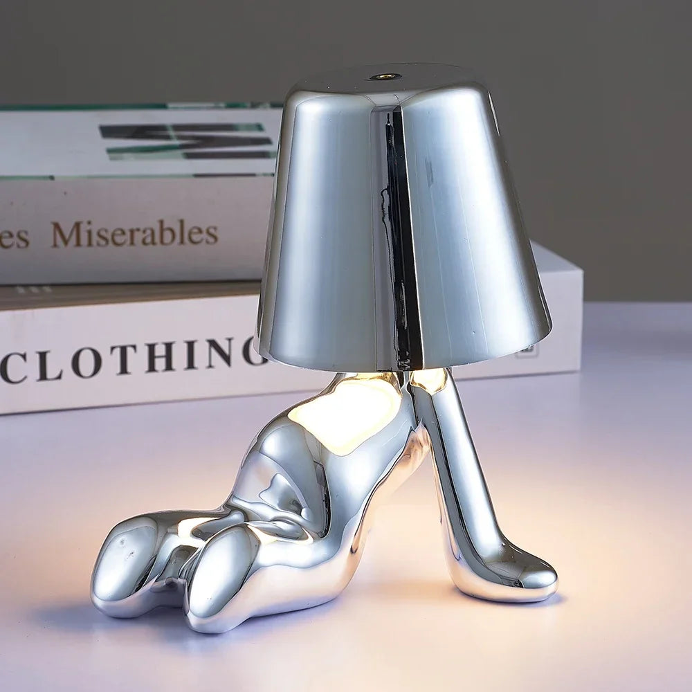 Designerska lampa stołowa LED siedzący człowiek z połyskującym wykończeniem