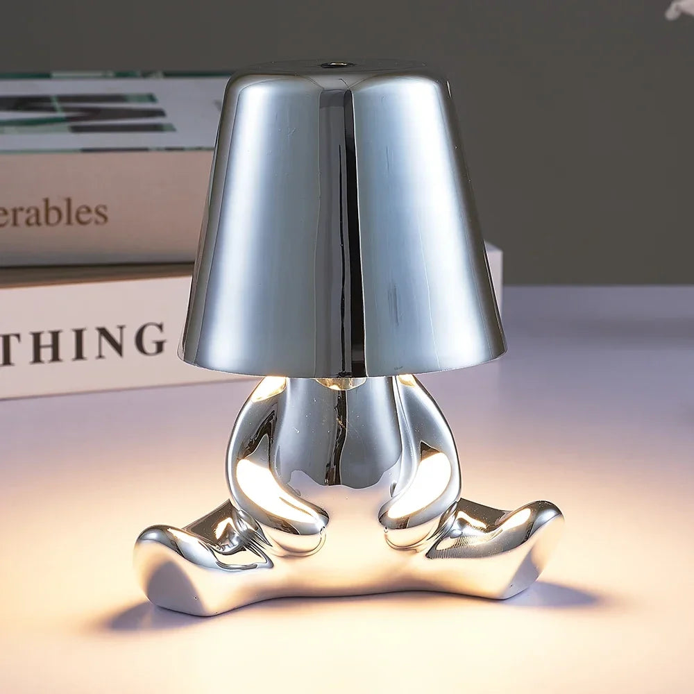 Designerska lampa stołowa LED siedzący człowiek z połyskującym wykończeniem