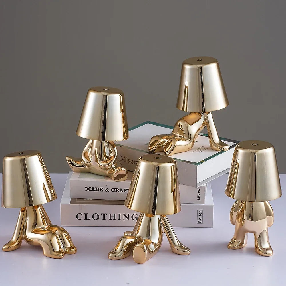 Designerska lampa stołowa LED siedzący człowiek z połyskującym wykończeniem