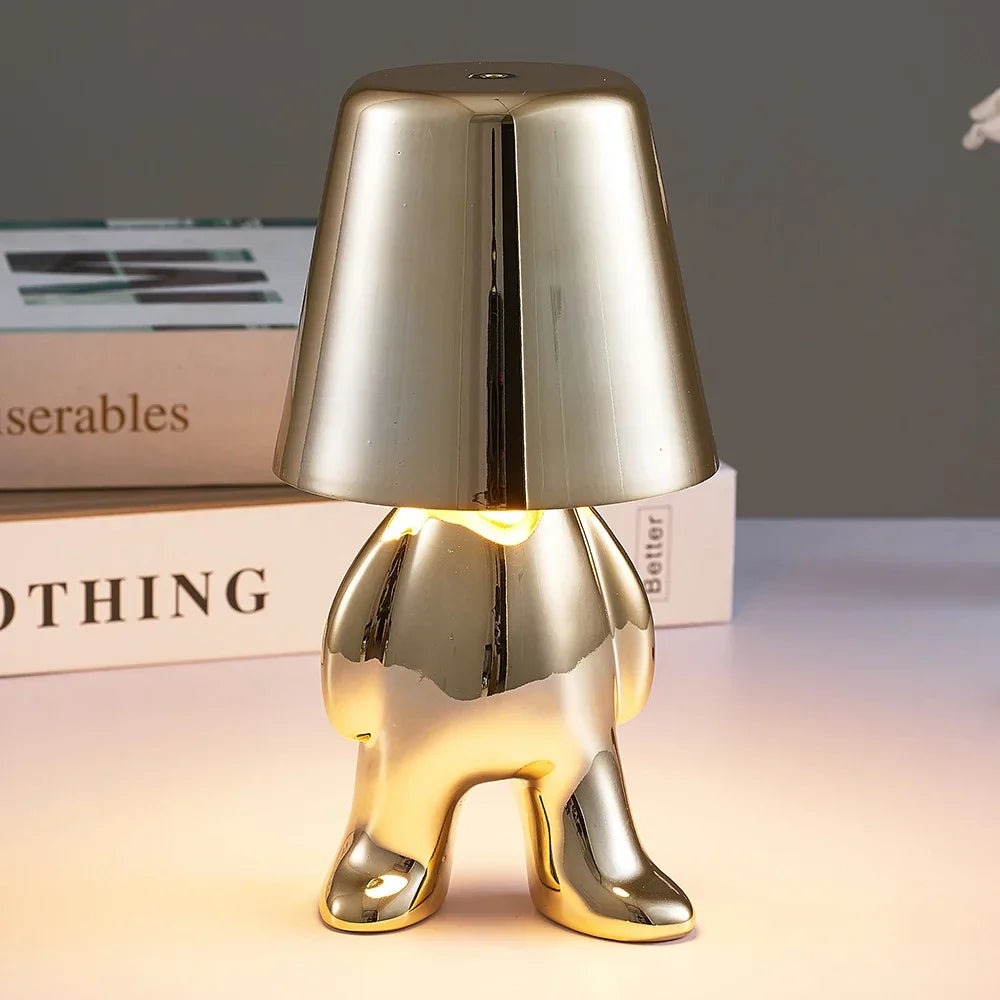 Designerska lampa stołowa LED siedzący człowiek z połyskującym wykończeniem