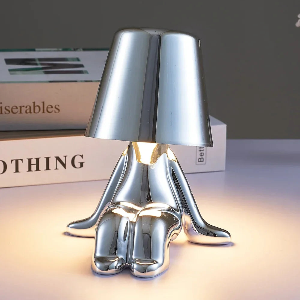 Designerska lampa stołowa LED siedzący człowiek z połyskującym wykończeniem
