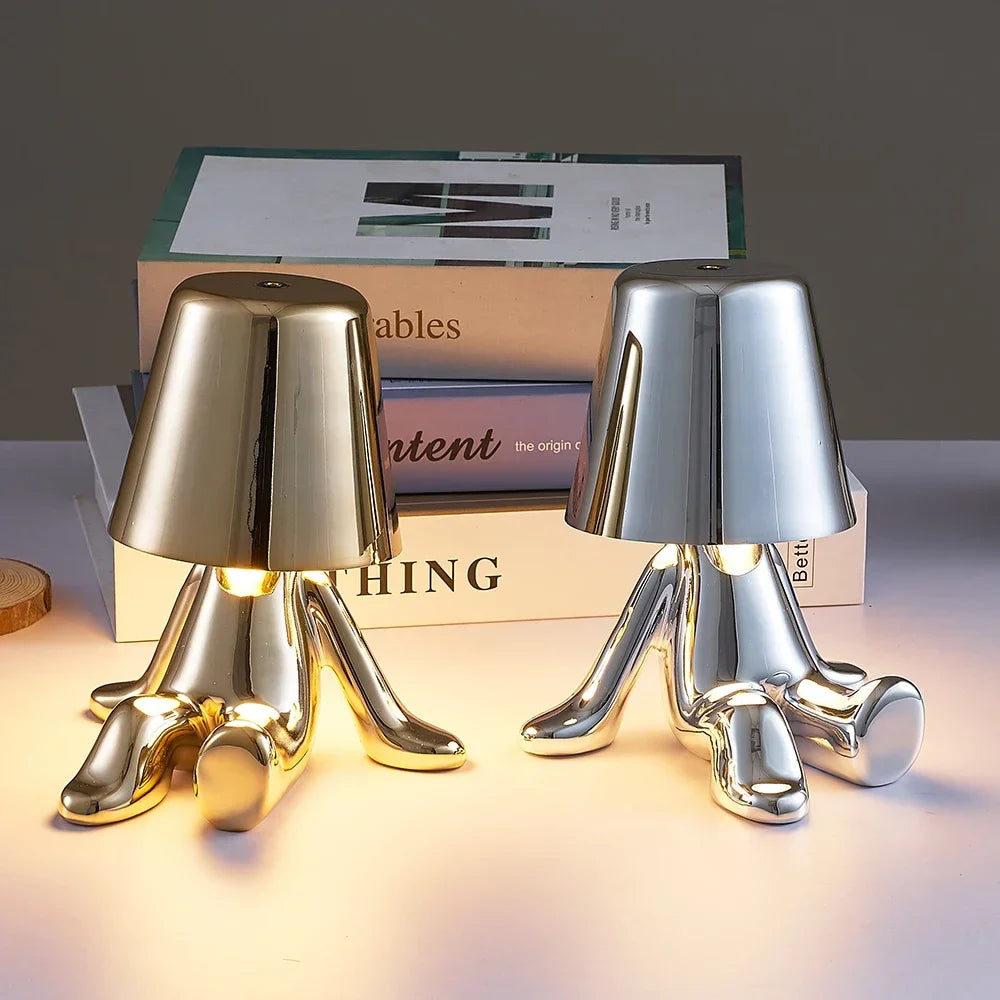 Designerska lampa stołowa LED siedzący człowiek z połyskującym wykończeniem